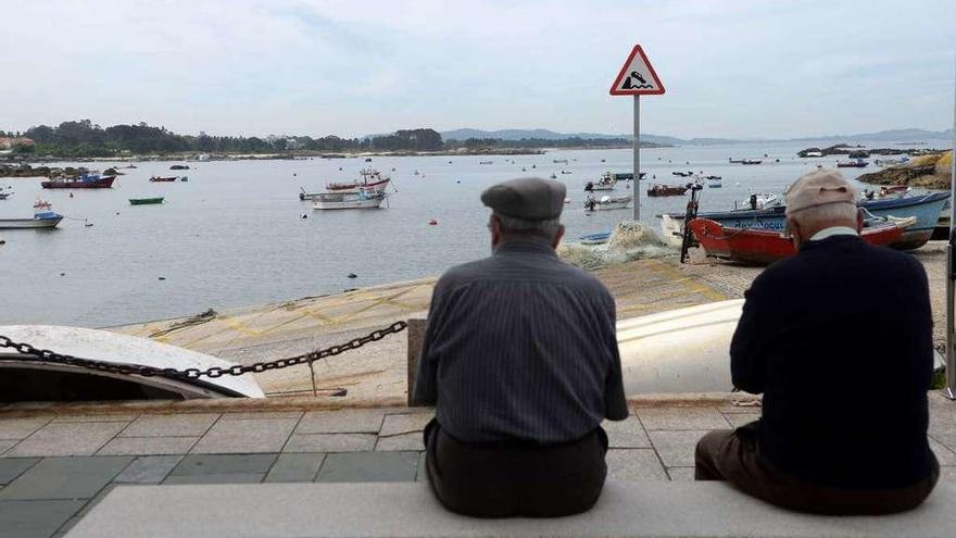 Dos jubilados observan el mar en las inmediaciones de A Carboneira, en A Illa. // Noé Parga