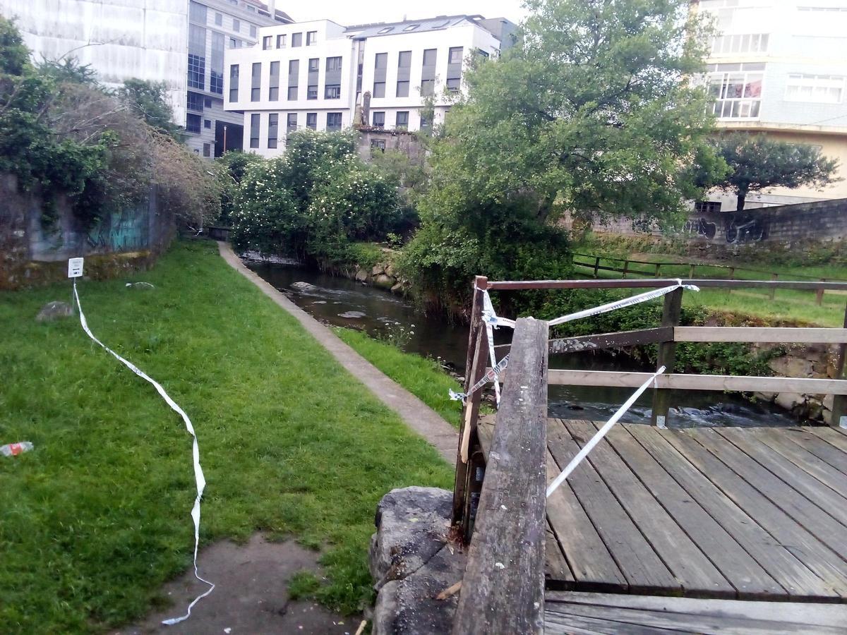 Pasarela de madera y tramo del río donde apareció el cuerpo