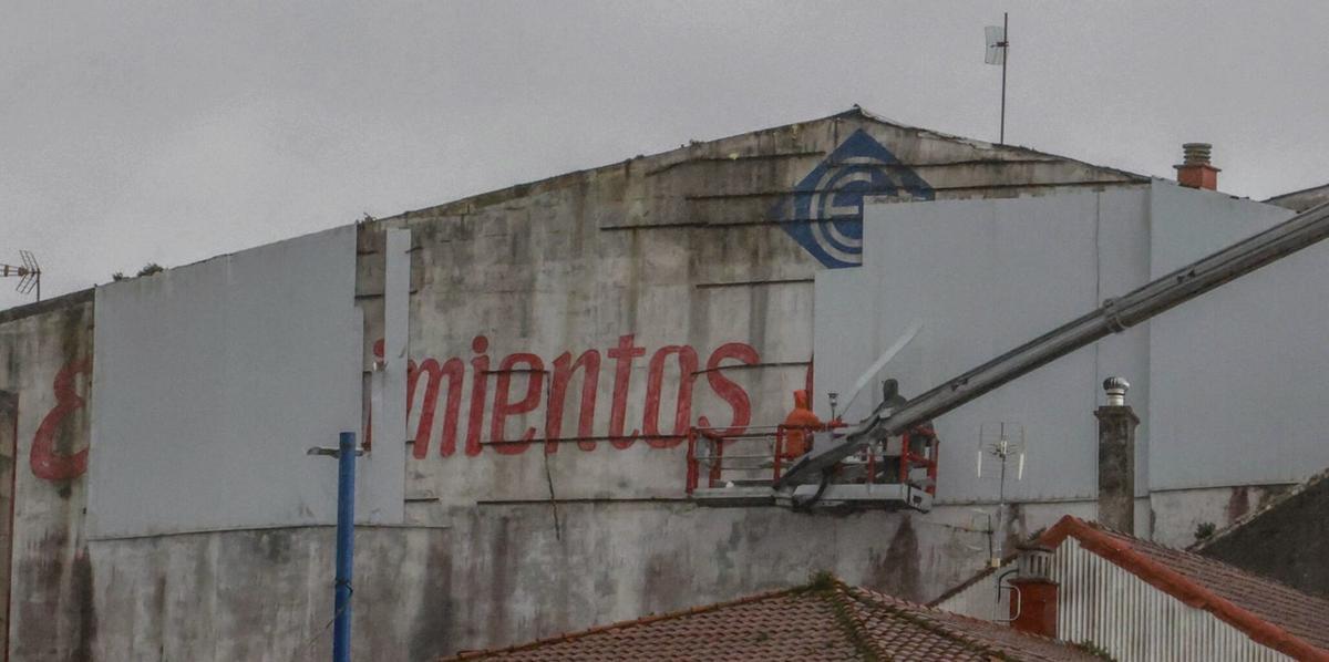 Operarios de la grúa contratada por el Ayuntamiento durante la retirada de las chapas que llevan tiempo cayendo. | IÑAKI ABELLA