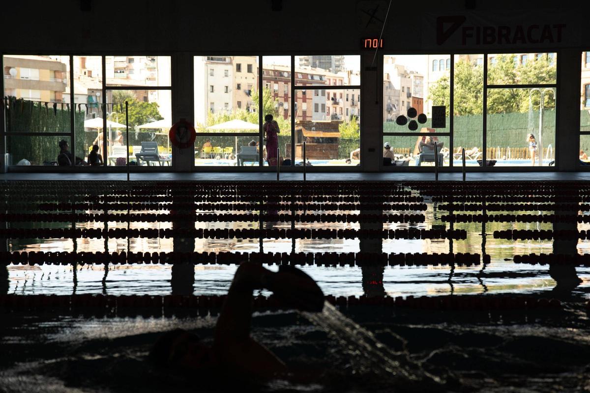 La piscina interior, gairebé buida, contrasta amb l'exterior