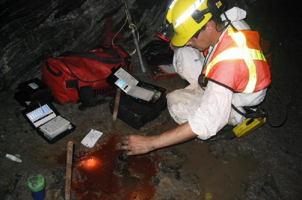 Un investigador extrayendo muestas del agua en la mina