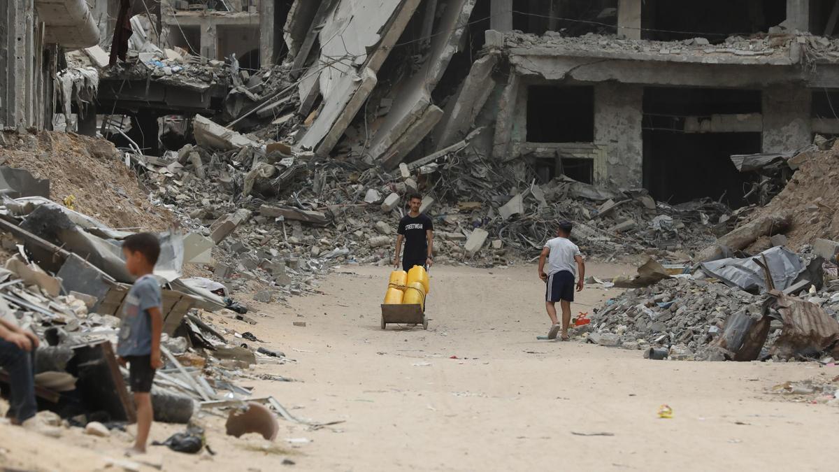 Varios niños, junto a las ruinas de edificios destruidos por bombardelos de Israel en Dair El-Balah, Gaza.