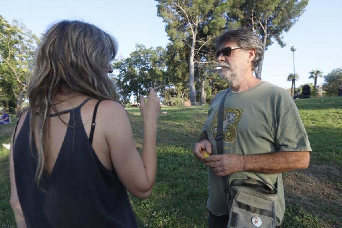 Una pareja fuma en el césped de un parque de Zaragoza. | ANDREEA VORNICU