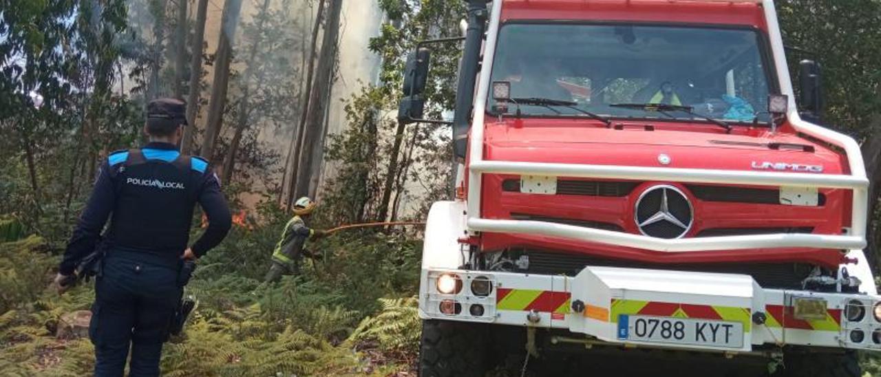 Los bomberos forestales y la Policía Local ayer en el incendio de A Caeira. |   // POLICÍA LOCAL DE POIO