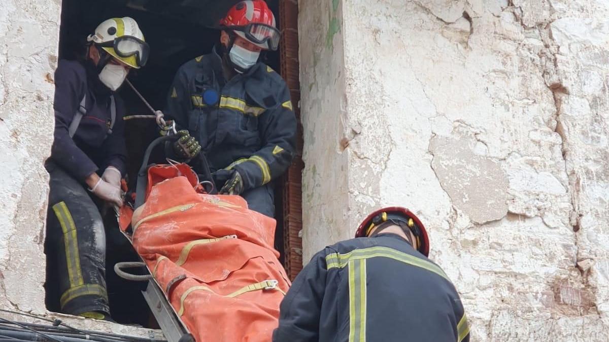 Los bomberos extraen a la víctima con una camilla.