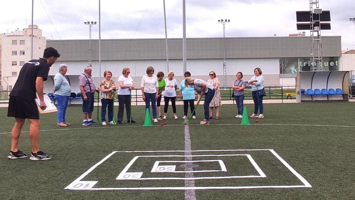 Un grupo de jubilados juega a hockey en el campo de fútbol de Boqueras.