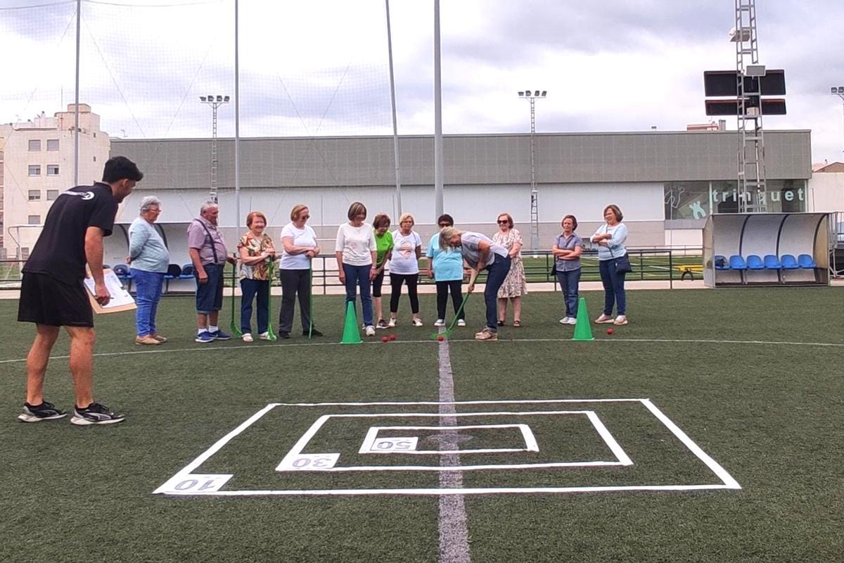 Un grupo de jubilados juega a hockey en el campo de fútbol de Boqueras.