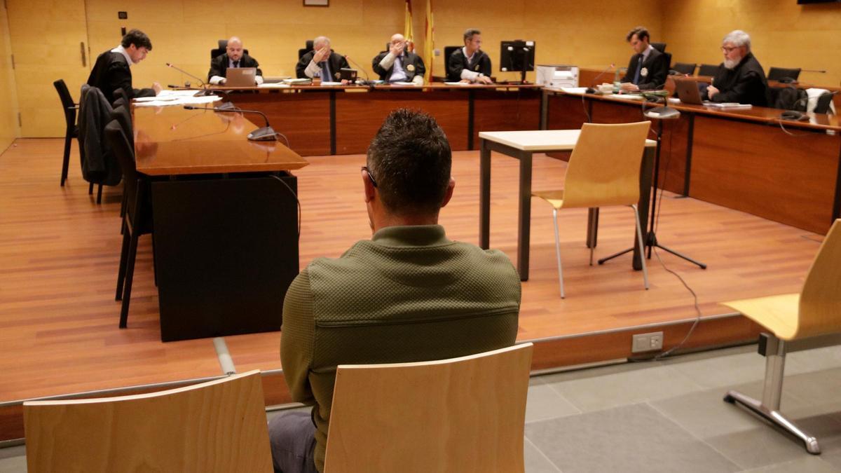 D'esquenes, l'acusat d'agredir sexualment una treballadora a Puigcerdà. Foto del judici a l'Audiència de Girona