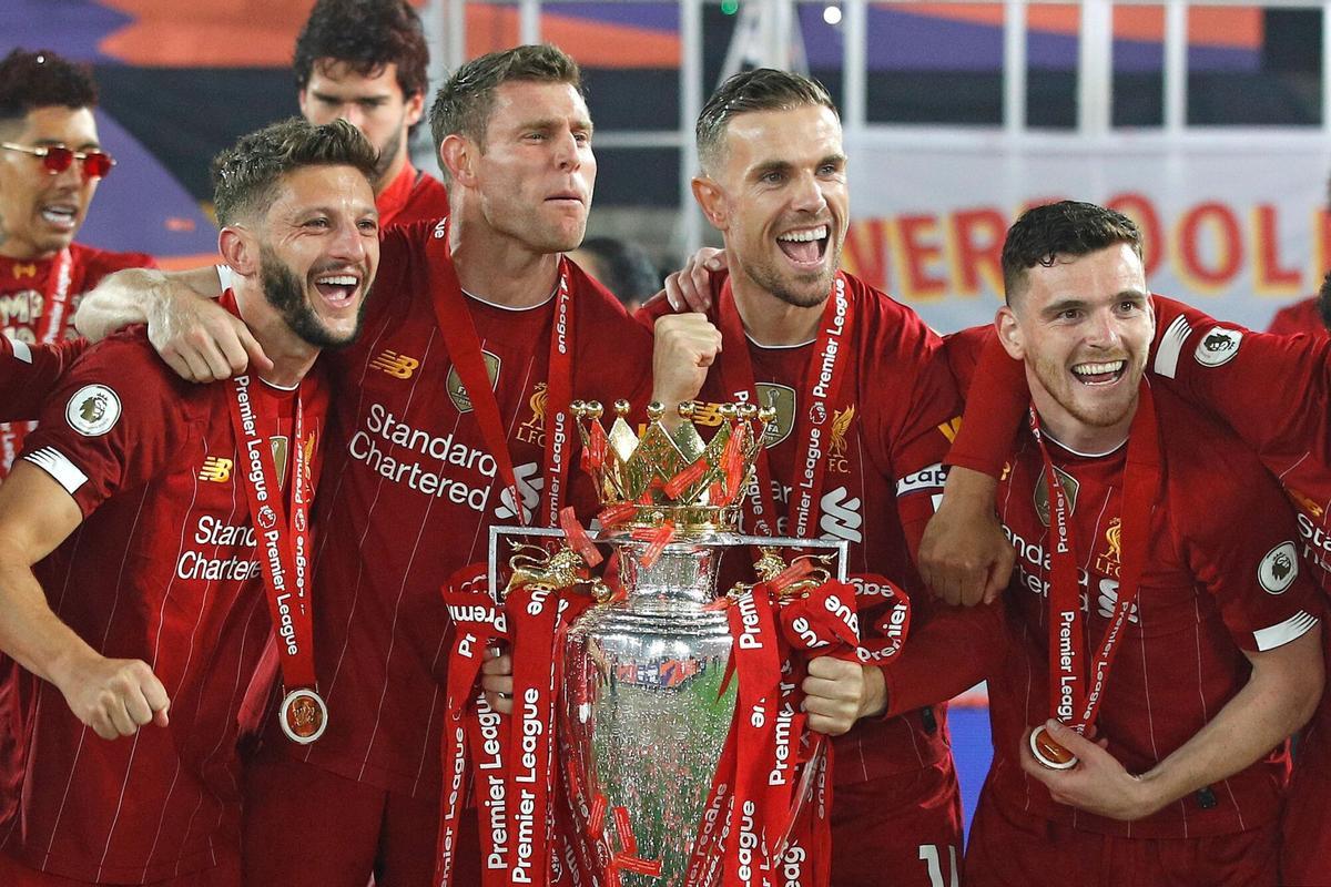 (L-R) Liverpool's English midfielder Adam Lallana, Liverpool's English midfielder James Milner, Liverpool's English midfielder Jordan Henderson and Liverpool's Scottish defender Andrew Robertson pose with the Premier League trophy during the presentation following the English Premier League football match between Liverpool and Chelsea at Anfield in Liverpool, north west England on July 22, 2020. - Liverpool on Wednesday lifted the Premier League trophy at the famous Kop stand at Anfield after their final home game of the season. With no fans able to attend due to the COVID-19 coronavirus pandemic, Liverpool said the idea for the trophy lift was to honour the club's fans, but Liverpool manager Jurgen Klopp urged fans to respect social distancing measures, after thousands gathered around the club's stadium and in the city centre following their coronation as champions last month. (Photo by PHIL NOBLE / POOL / AFP) / RESTRICTED TO EDITORIAL USE. No use with unauthorized audio, video. HORIZONTAL