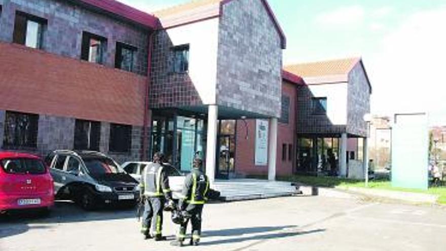 Dos bomberos, ante el centro de salud de Noreña.