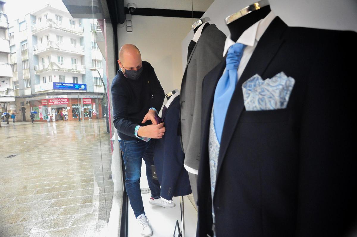 Miguel Lema preparando algunos de los trajes que lucen en su escaparate.