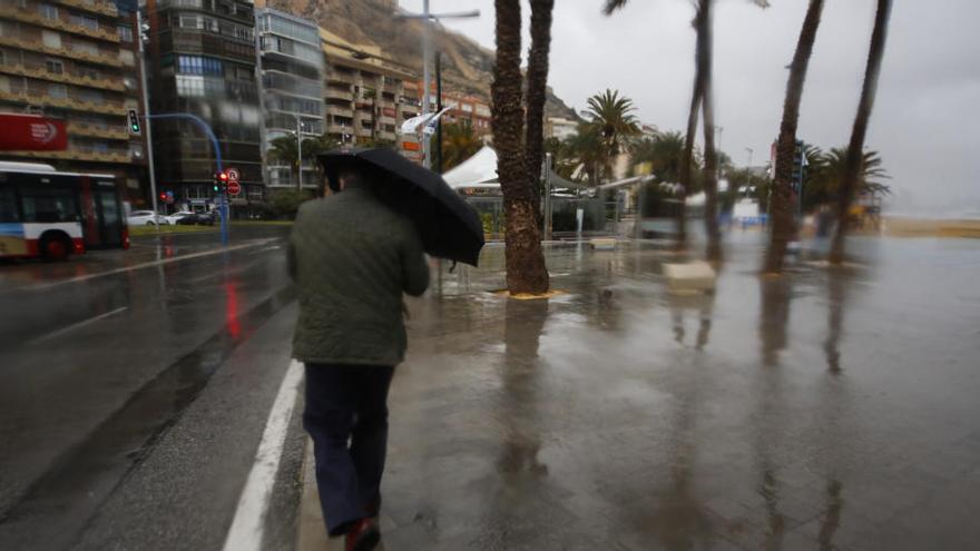 Un hombre se protege de la lluvia en el paseo de Gómiz en uno de los temporales de enero