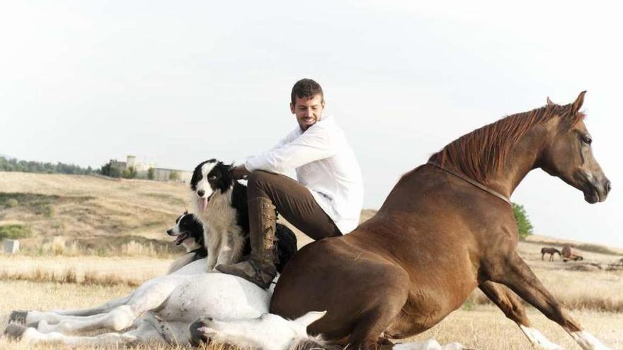 Santi Sierra posa junto a varios de sus caballos y perros.