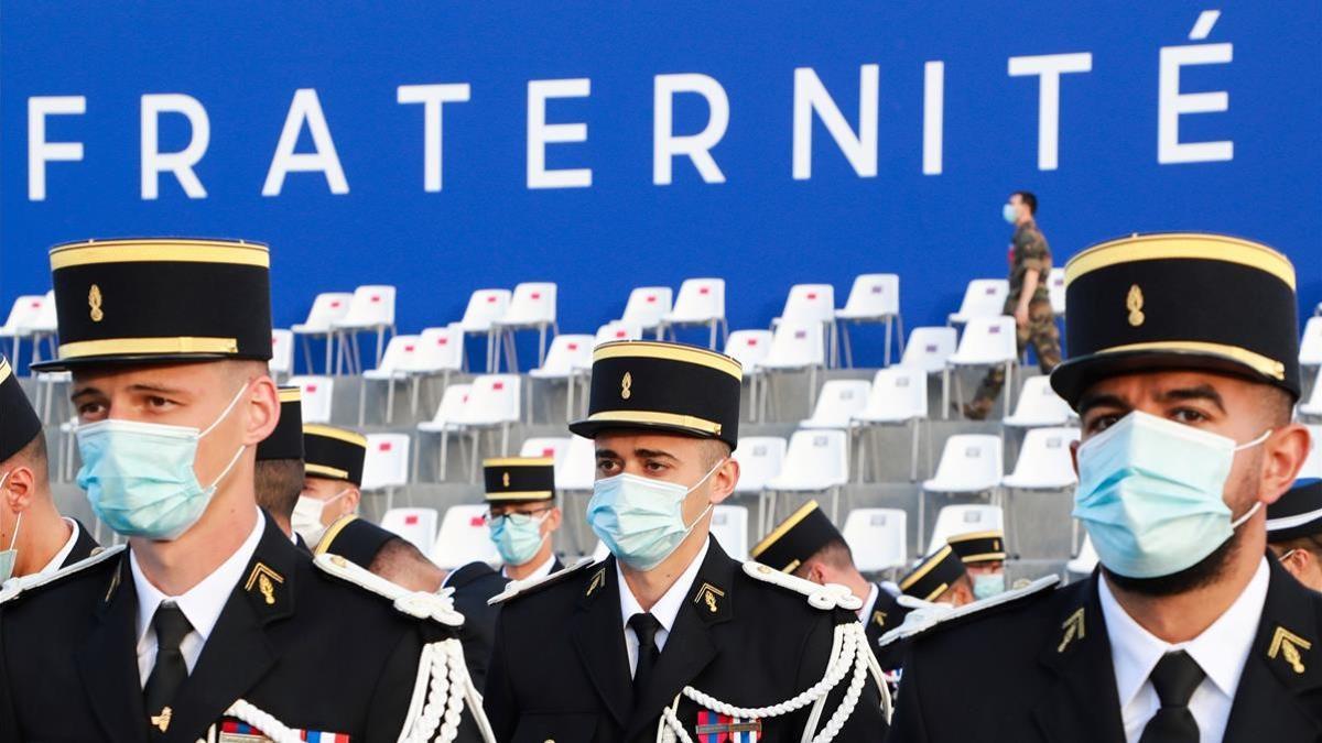 TOPSHOT - French Gendarmes wearing protective facemasks arrrive prior to the annual Bastille Day military ceremony on the Place de la Concorde in Paris  on July 14  2020  - France holds a reduced version of its traditional Bastille Day parade this year due to safety measures over the COVID-19 (novel coronavirus) pandemic  and with the country s national day celebrations including a homage to health workers and others fighting the outbreak  (Photo by Ludovic Marin   AFP)