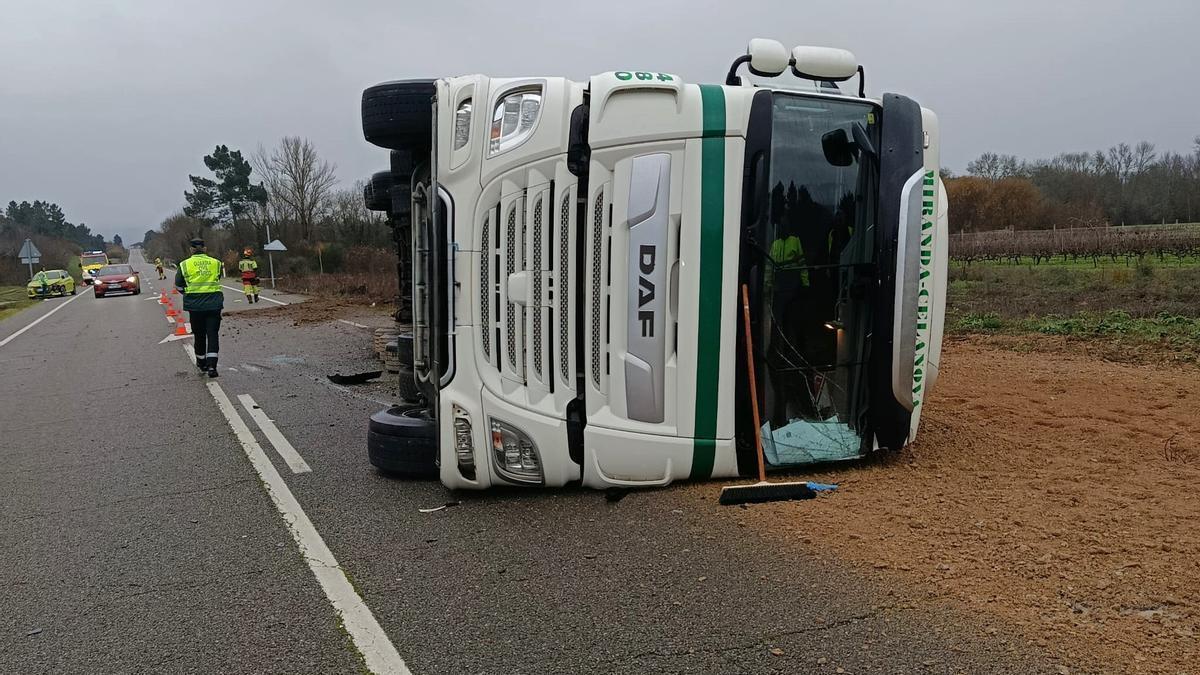 El camión volcado y la arena esparcida en el asfalto.