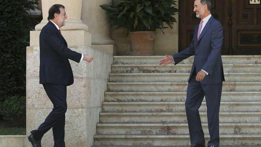 Mariano Rajoy y Felipe VI se saludan ayer a la entrada del palacio de Marivent.