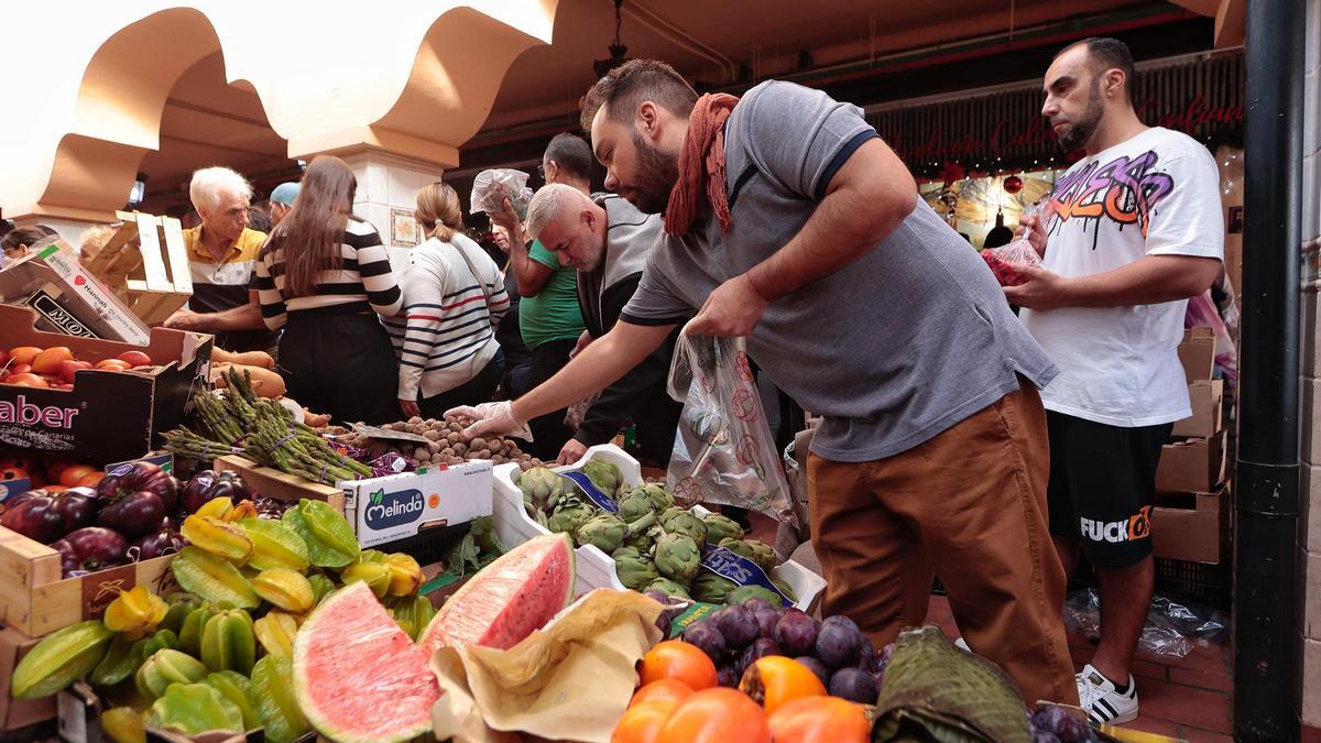 Un hombre escoge fruta en el mercado.
