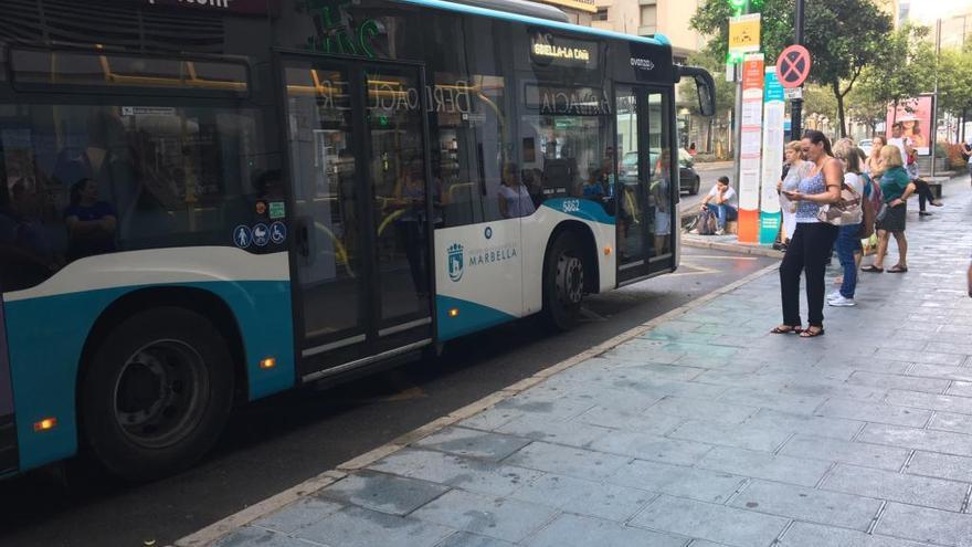 Viajeros esperan a un autobús urbano en el centro de Marbella.