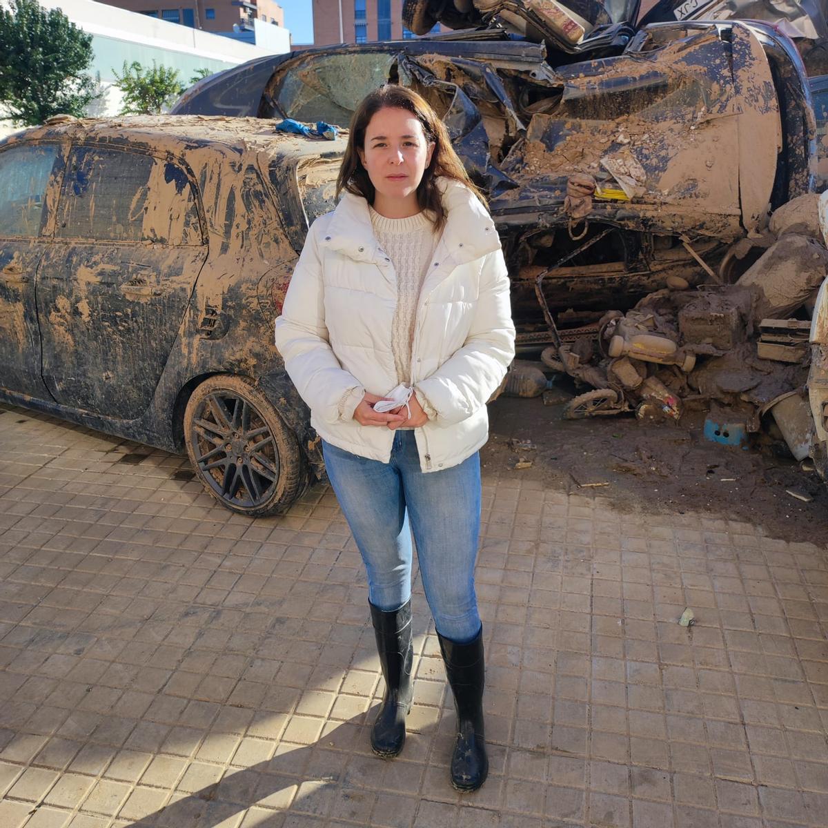 Meri junto al cementerio de coches que tiene en frente de su casa en Catarroja.