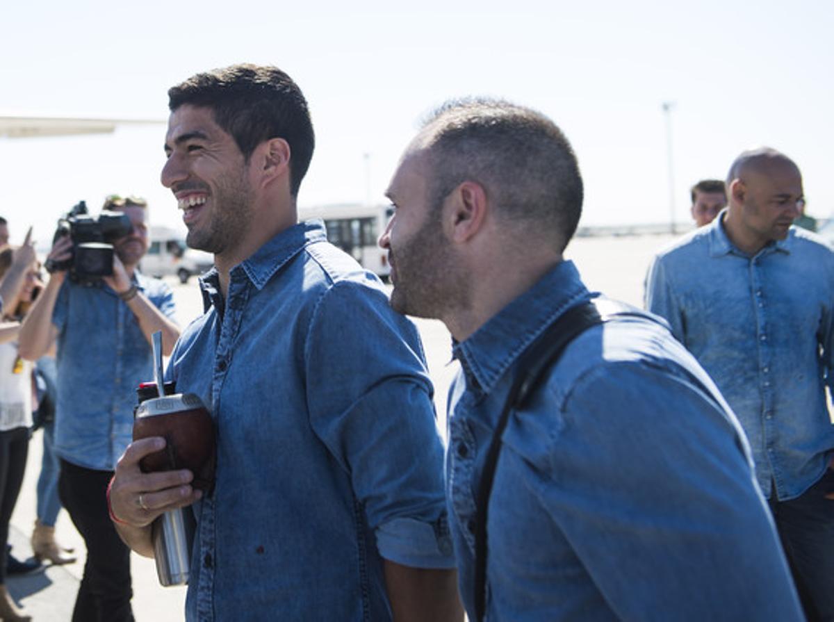 Suárez e Iniesta, se dirigen sonrientes al avión que lleva a la expedición del Barça a la final de la champions.