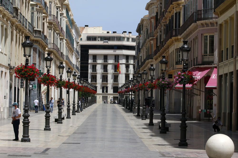 Mascarillas y guantes ya se han convertido en un complemento más de los malagueños, que siguen aprovechando las franjas horarias permitidas para dar sus paseos mientras los pequeños establecimientos se preparan para una reapertura cuando el progreso en la desescalada lo permita