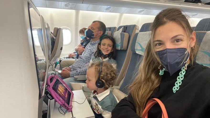Raquel Arias con su marido y sus dos hijos en el avión hacia París, este lunes.