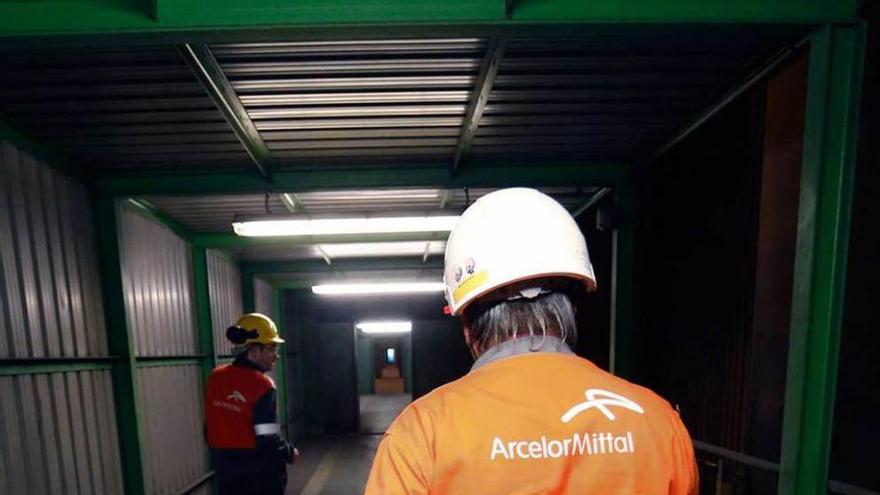 Dos trabajadores de Arcelor-Mittal acuden a su puesto en Avilés.