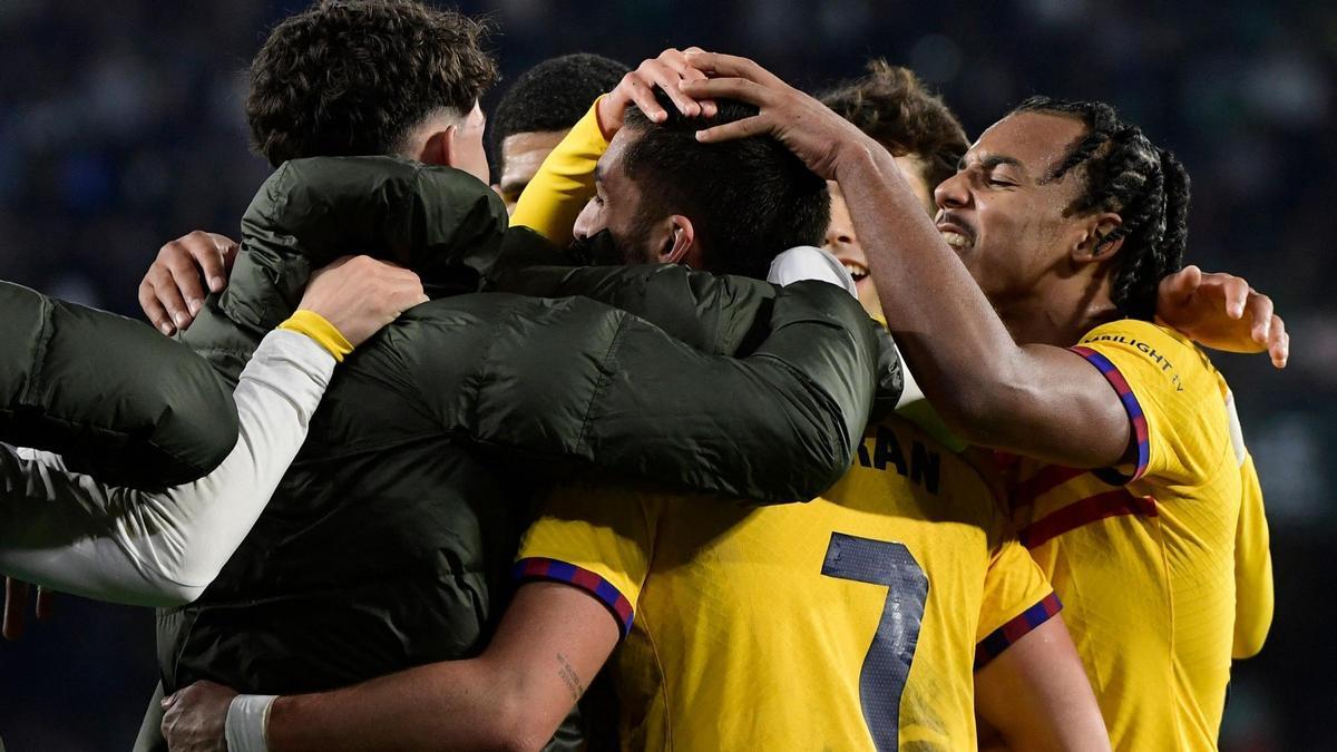 Los futbolistas del Barça se agolpan junto a Ferran Torres tras culminar su triplete.