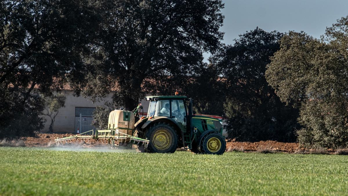 Un tractor vertiendo nitratos en terrenos de cultivo del término municipal.