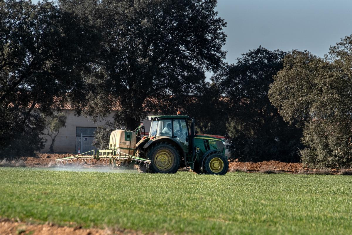 Un tractor vertiendo nitratos en terrenos de cultivo del término municipal.