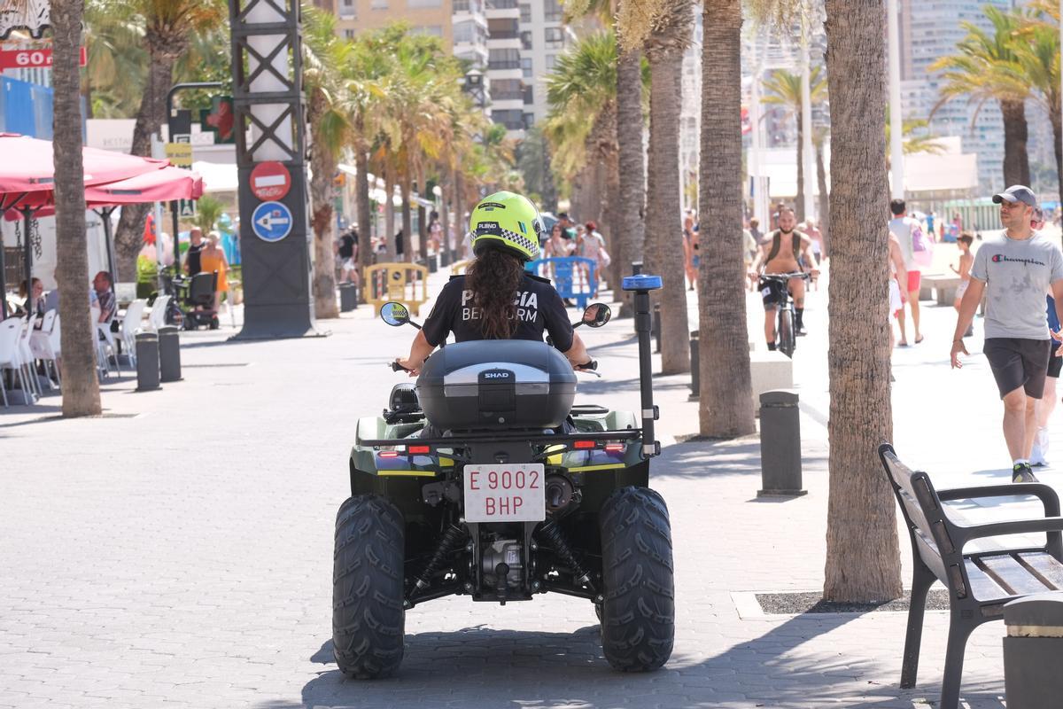 Una agente de la Policía Local de Benidorm patrulla en un quad por la primera línea de la playa de Levante, el pasado verano.