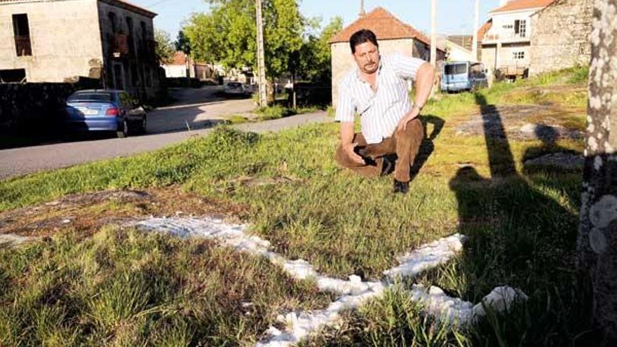 Miguel Montoya posa ante la cruz de sal que le han puesto junto a su vivienda.