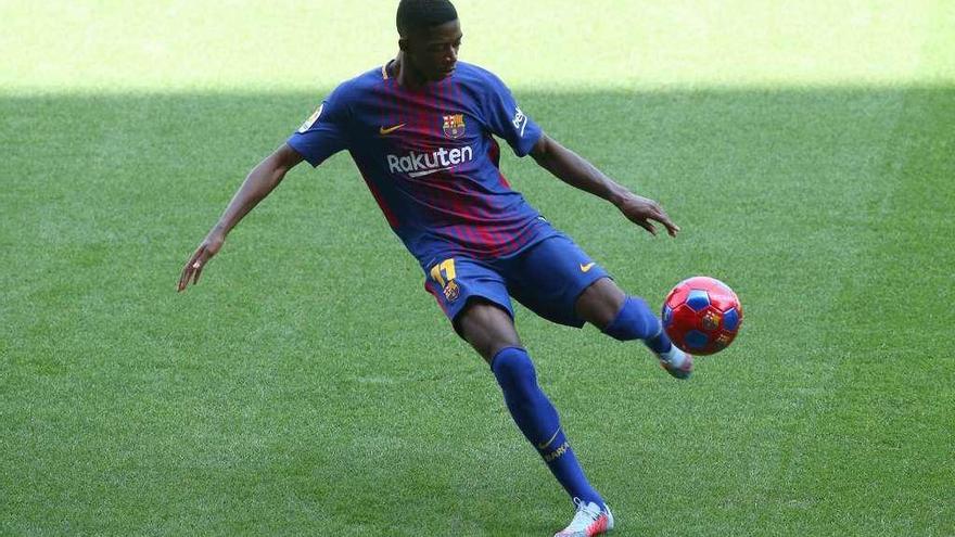 Ousmane Dembélé lanza un balón a la grada en el acto de su presentación en el Camp Nou.