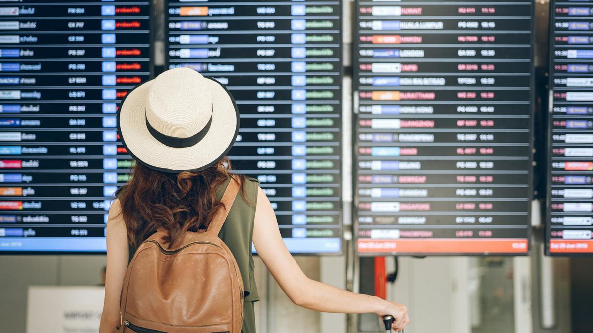 Una turista consulta su vuelo en el panel del aeropuerto.