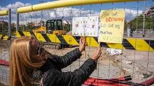 Una manifestante cuelga unas pancartas contra la tala de árboles en el parque de Joan Miró, en Barcelona.