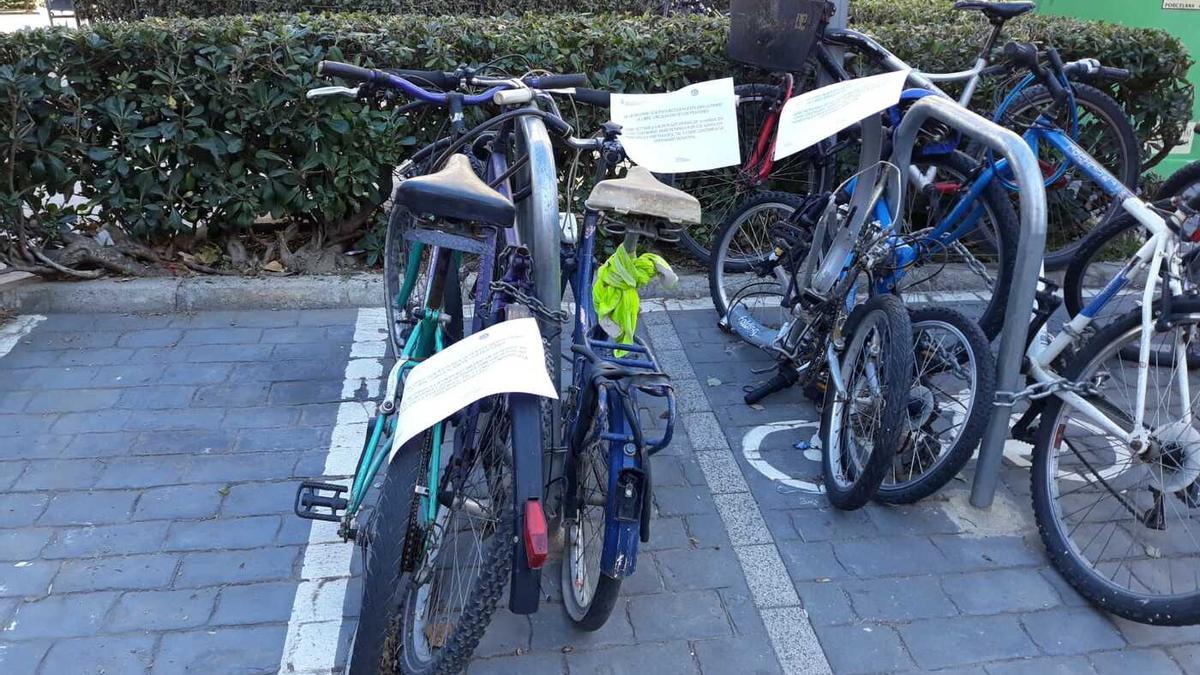 La Policía Local coloca notas informaticas en bicicletas mal estacionadas para pedir su retirada.