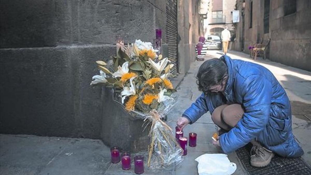 Una vecina del Born enciende unas velas en el lugar donde un hombre de 60 años fue mortalmente degollado el miércoles.