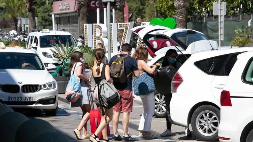 Un grupo de turistas carga sus maletas en un taxi de la parada del aeropuerto. | VICENT MARÍ