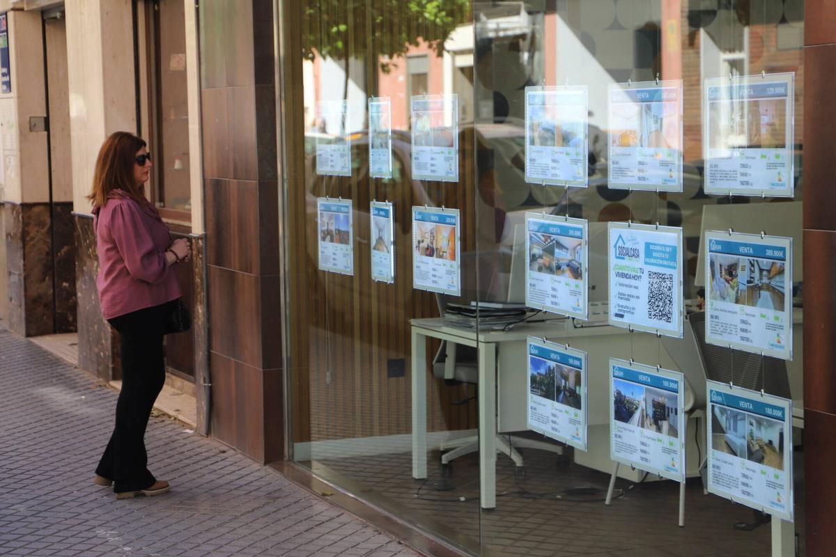 Una mujer observa los precios de una inmobiliaria cordobesa.