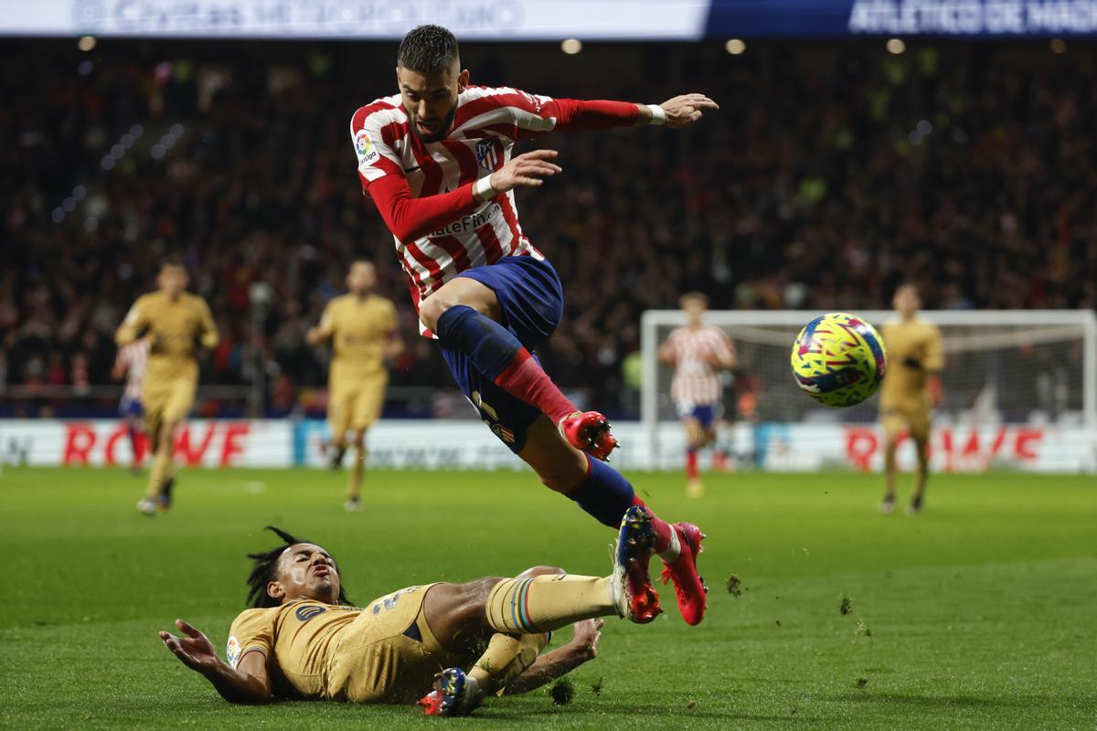 MADRID, 08/01/2023.- El centrocampista belga del Atlético de Madrid, Yannick Carrasco (d), cae ante el defensa francés del FC Barcelona, Jules Koundé, durante el encuentro correspondiente a la jornada 16 de primera división que disputan hoy domingo en el estadio Metropolitano, en Madrid. EFE / J.J. Guillen.