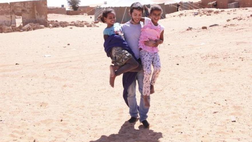 Eduardo Vicente Movilla juega con dos niños.