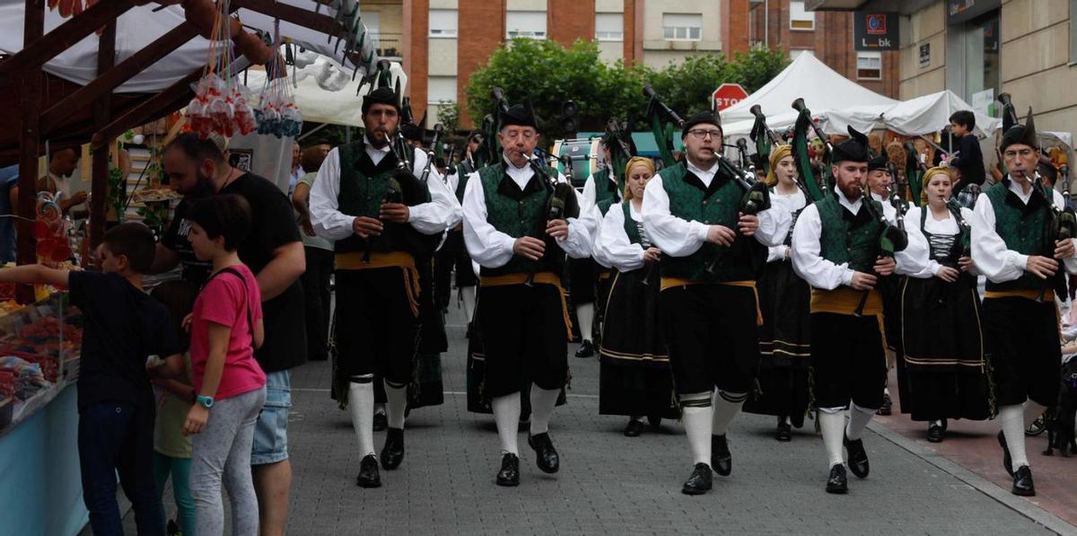 Arriba, ambiente en las calles de Piedras Blancas; sobre estas líneas, pasacalle de la Banda de Gaitas de Castrillón. | Mara Villamuza