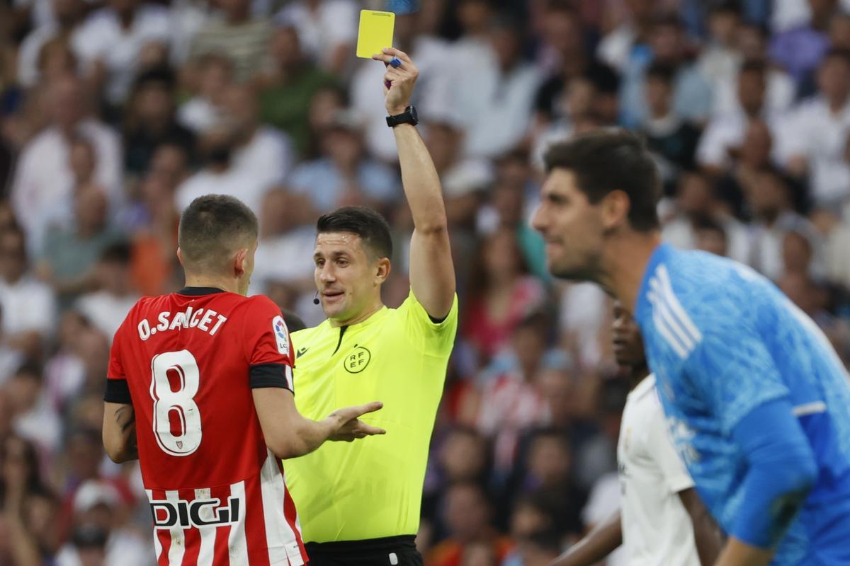 MADRID, 04/06/2023.- El colegiado Diaz de Mesa muestra tarjeta amarilla l centrocampista del Athletic Club, Oihan Sancet, durante el partido de la última jornada de Liga que el Real Madrid y el Athletic Club de Bilbao disputan este domingo en el estadio Santiago Bernabéu. EFE/ Mariscal.