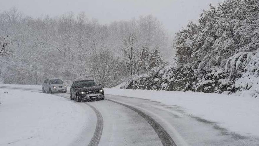 Dos vehículos transitan por una carretera nevada. // Brais Lorenzo