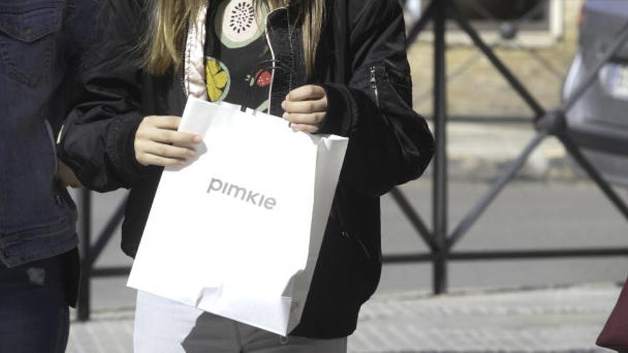 Una adolescente pasea por el centro de Vila después de haber comprado en una tienda.