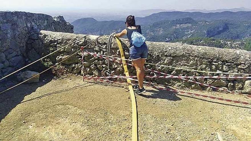 Una joven se asoma para ver como cuelga la manguera de presiÃ³n que se usa para subir agua.