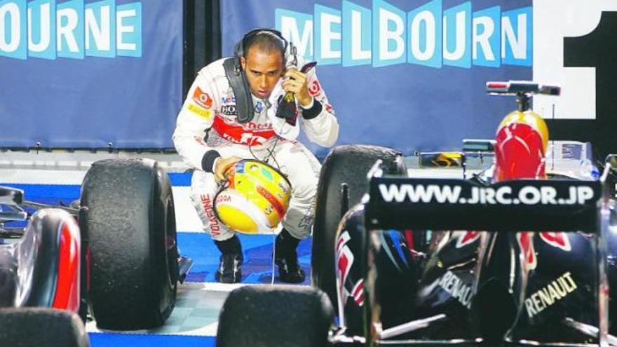 El británico Lewis Hamilton (McLaren) observa de cerca el Red Bull ganador de Sebastian Vettel una vez finalizada la carrera de Melbourne.