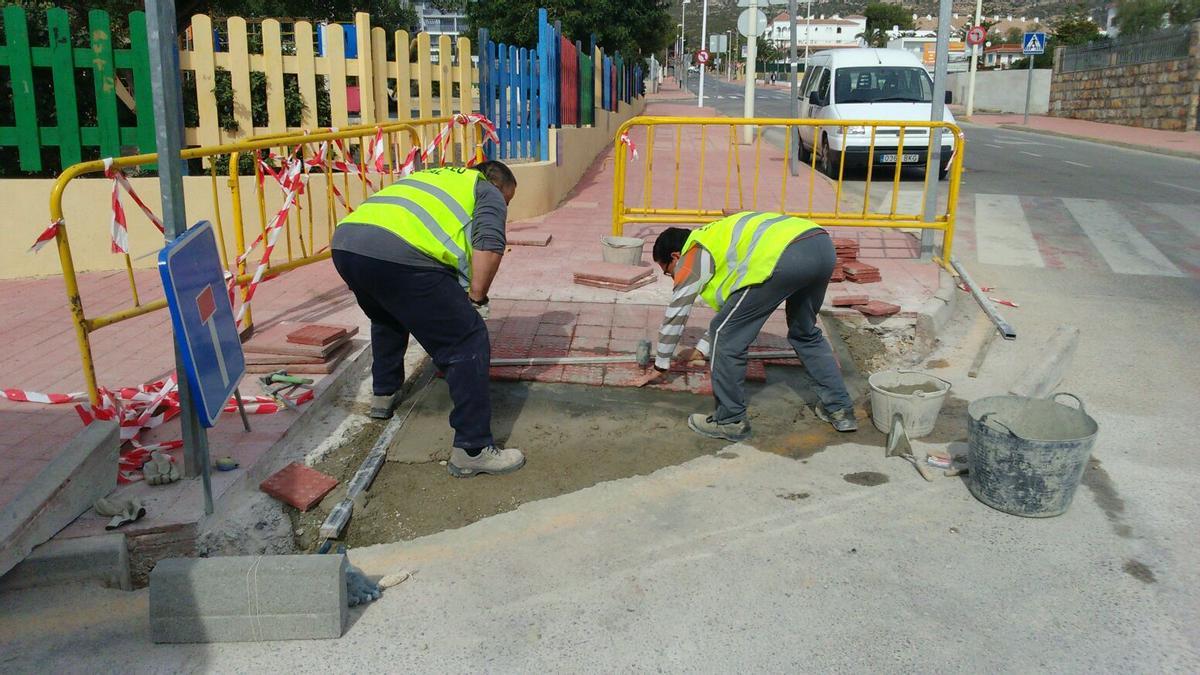 Dos operarios trabajan en la adecuación de las aceras en una localidad de la provincia de Castellón (archivo).