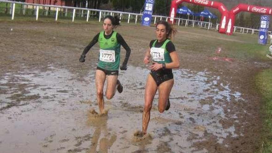 María Suárez y Marta Casanova pasan por una zona embarrada.