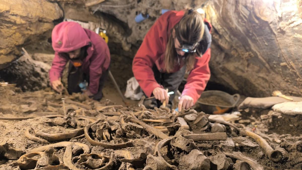 Arqueòlogues destapant restes humanes del jaciment de Roc de les Orenetes